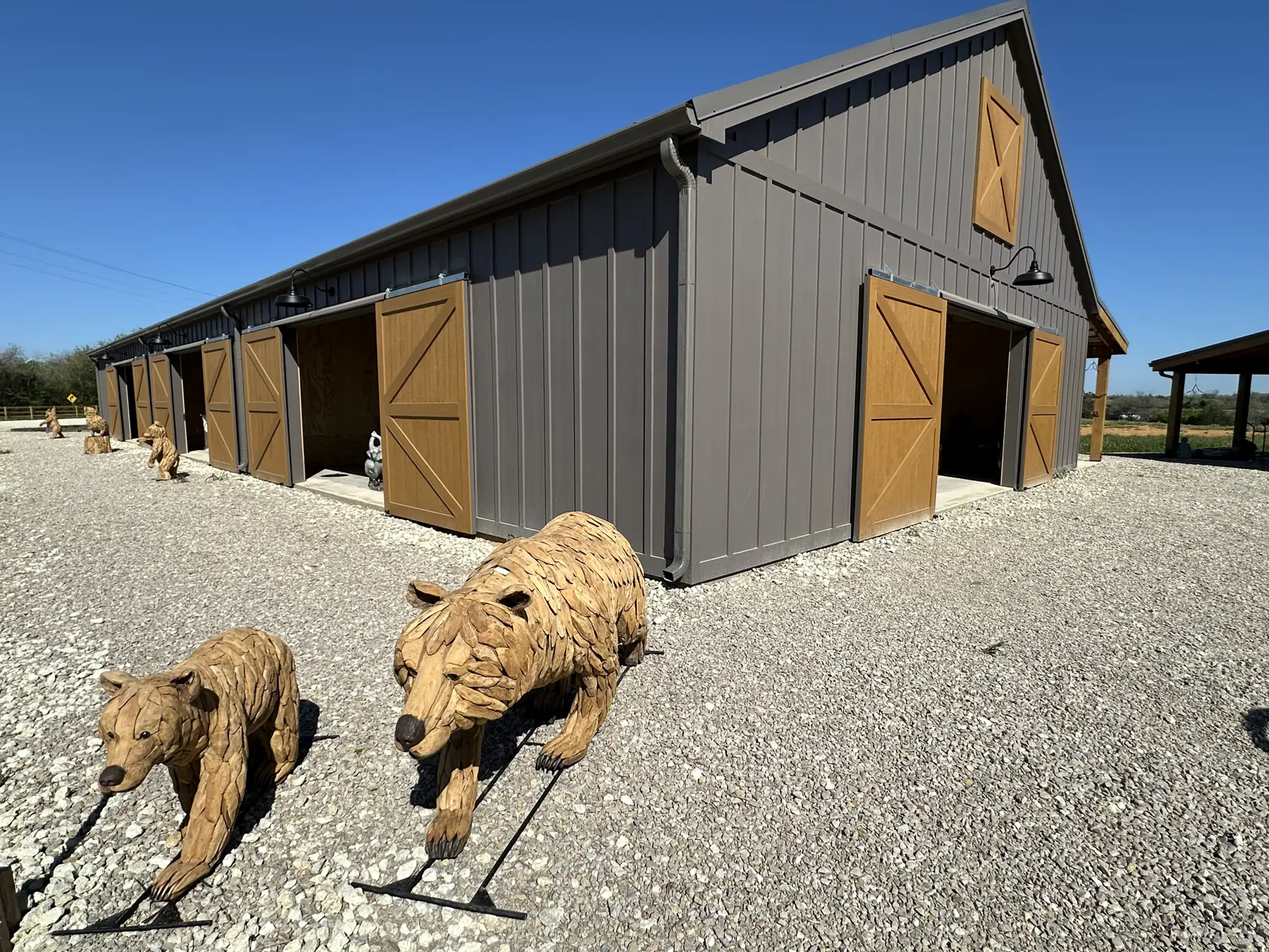 Carved wooden bears prowling the gravel outside The Hive