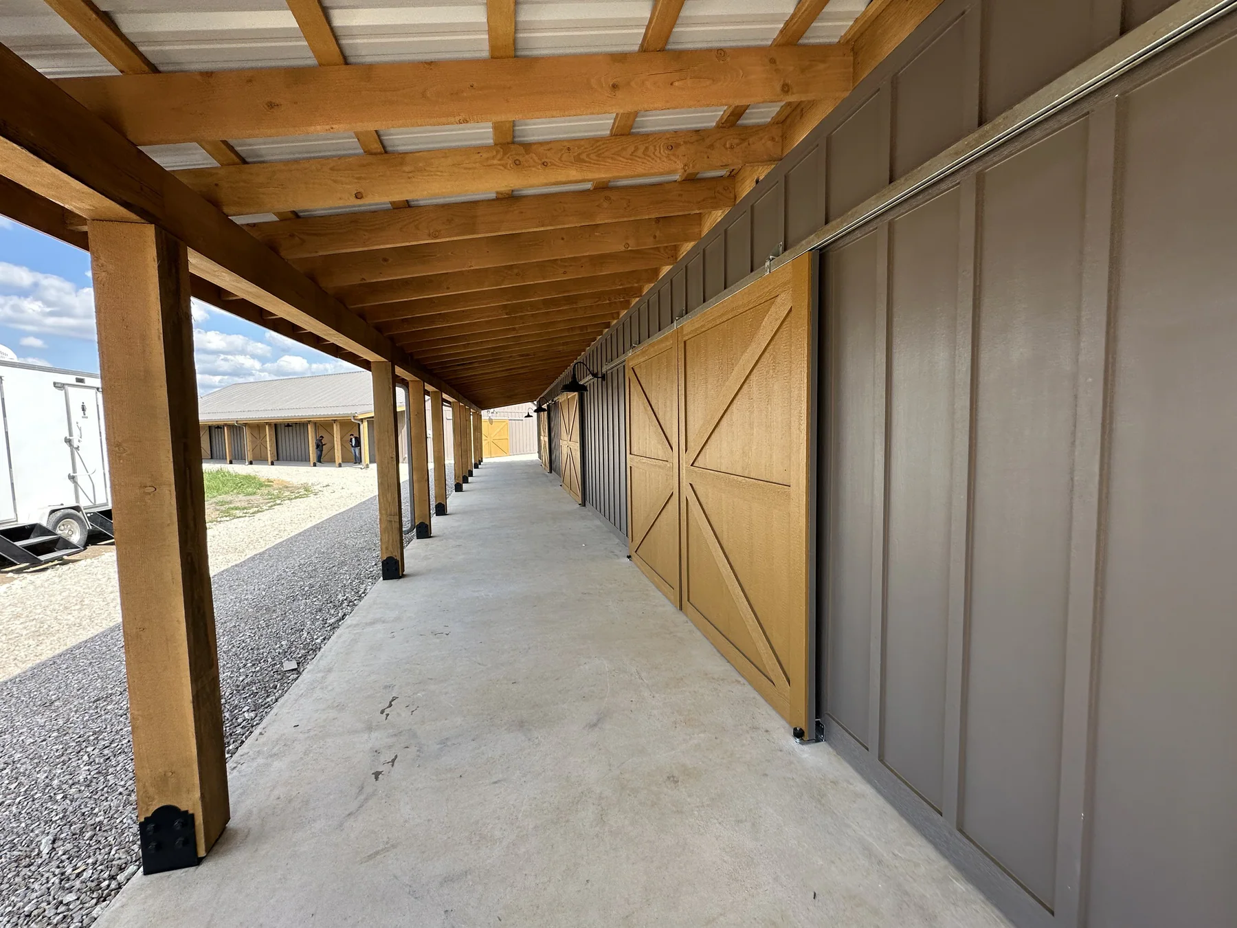 Long covered walkway and wooden barn doors at The Hive
