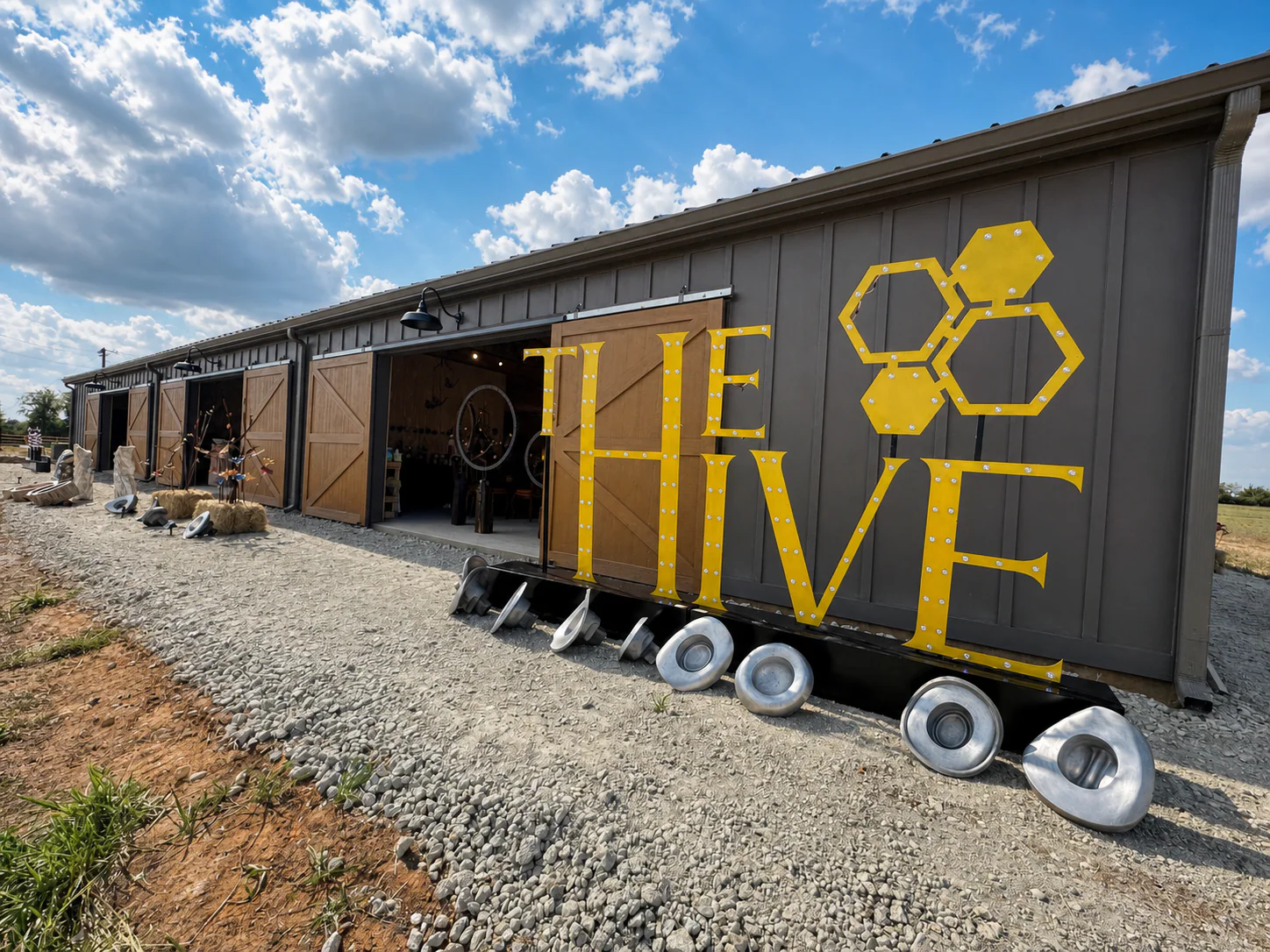 The Hive facade and illuminated yellow sign under a blue Texas sky