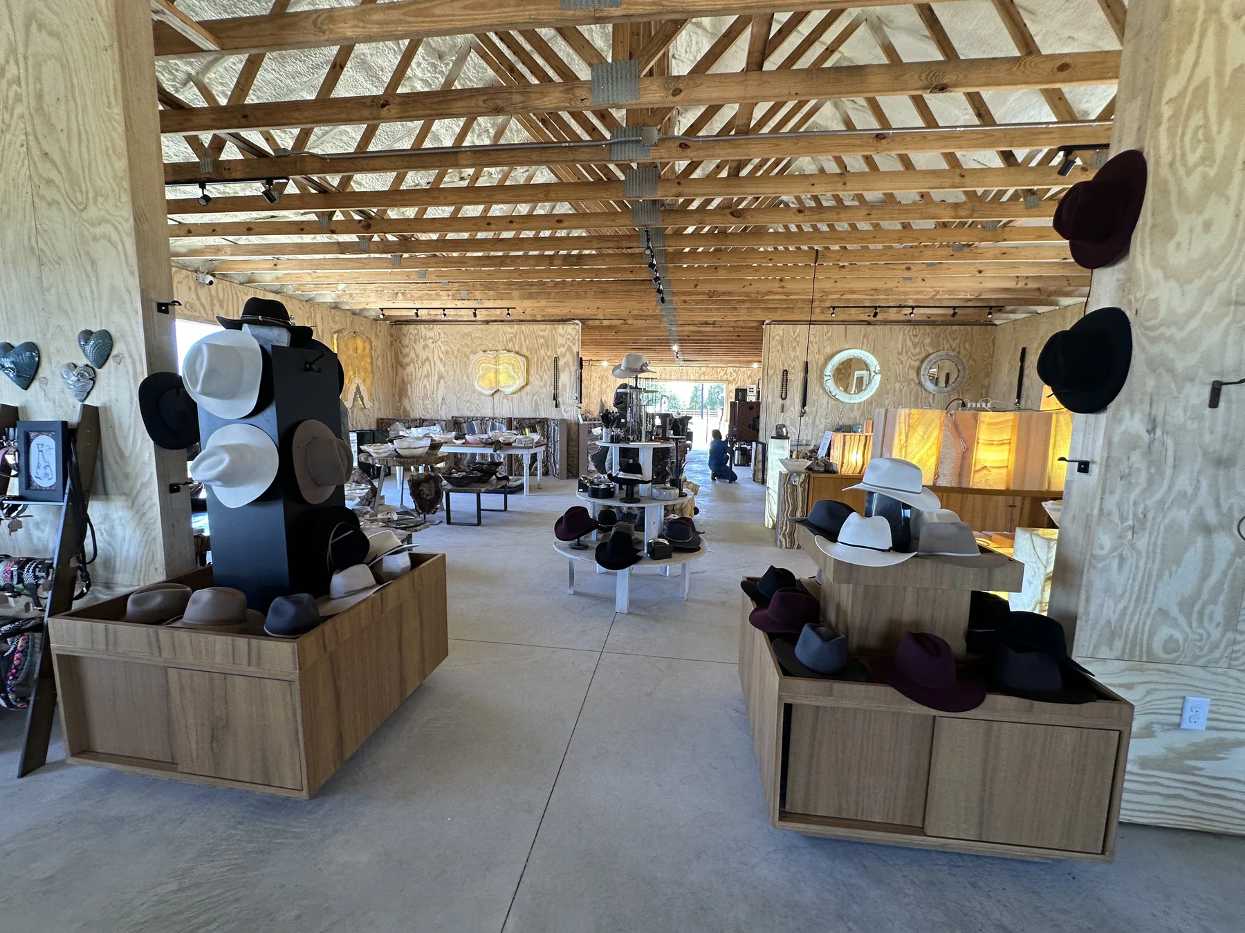 Wide interior view of vendor displays and handmade hats at The Hive