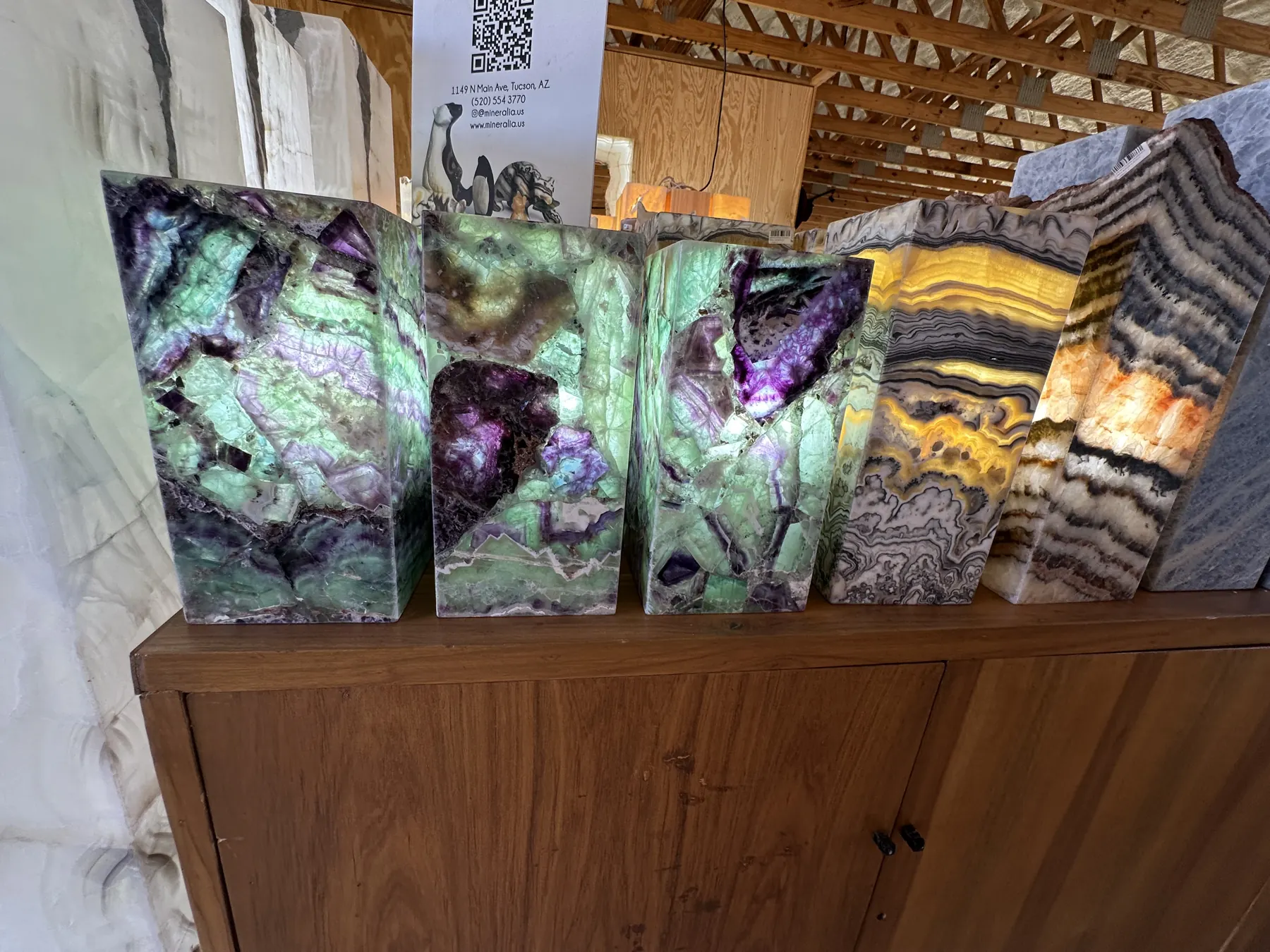 Colorful polished mineral slabs displayed on a wooden cabinet at The Hive